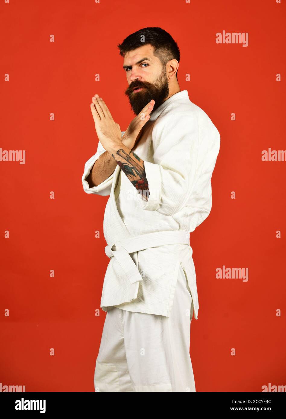 Japanese martial arts concept. Man with beard in white kimono on red