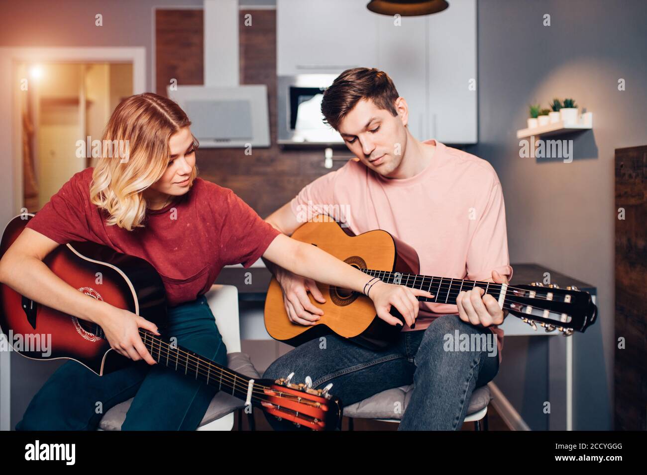Beautiful Caucasian Girl Show At Strings Of Guitar While Teaching Boy