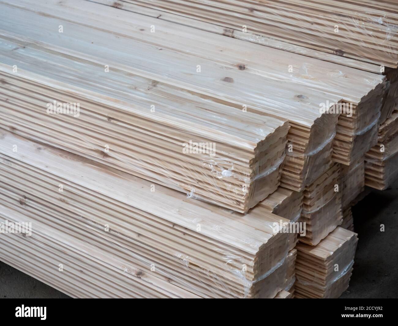 Stacks of construction lumber on a dusty construction site, showcasing the rough, untreated boards ideal for framing but ill-suited for furniture