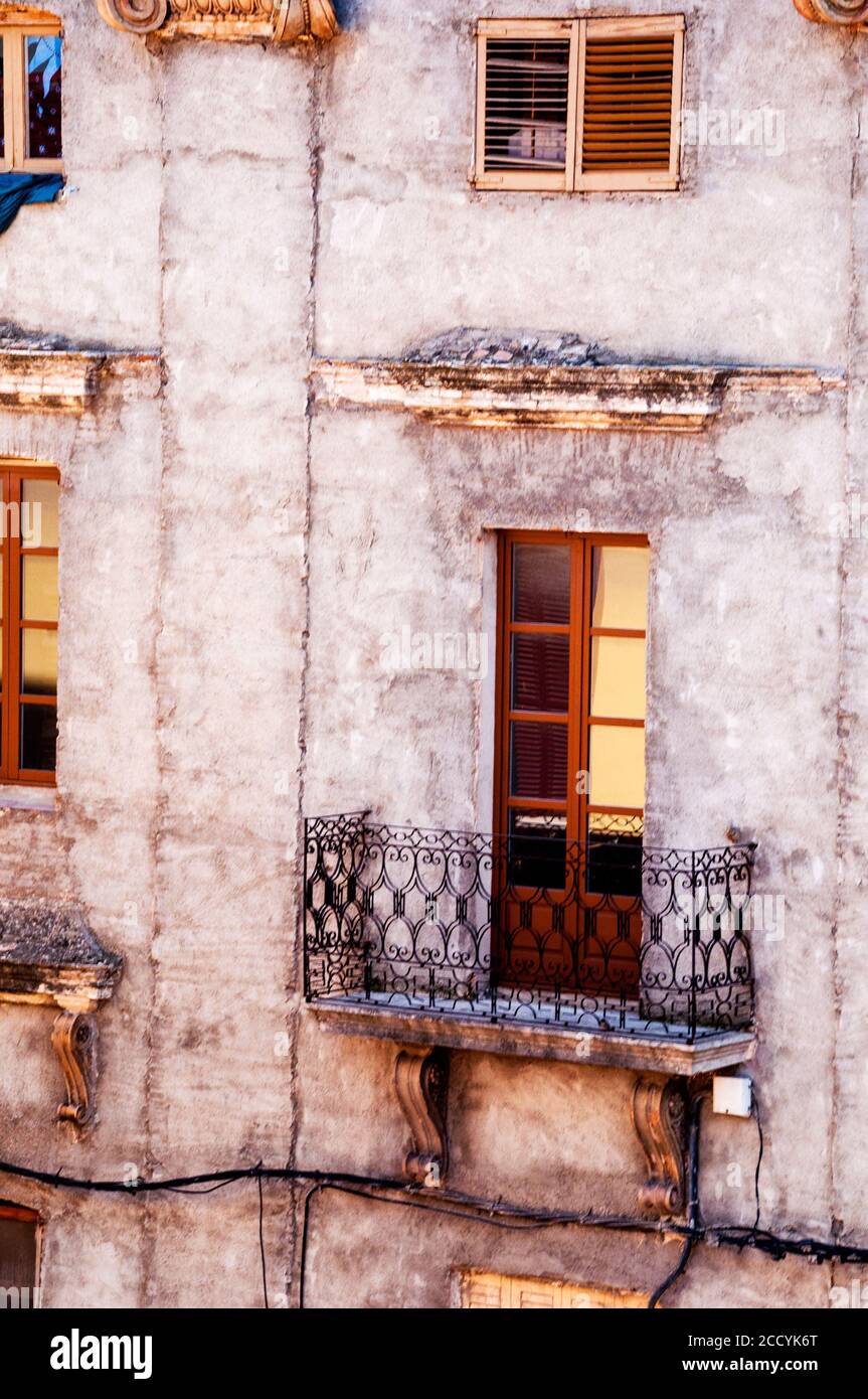 A beautiful iron railing on a balcony above carved corbels on an old