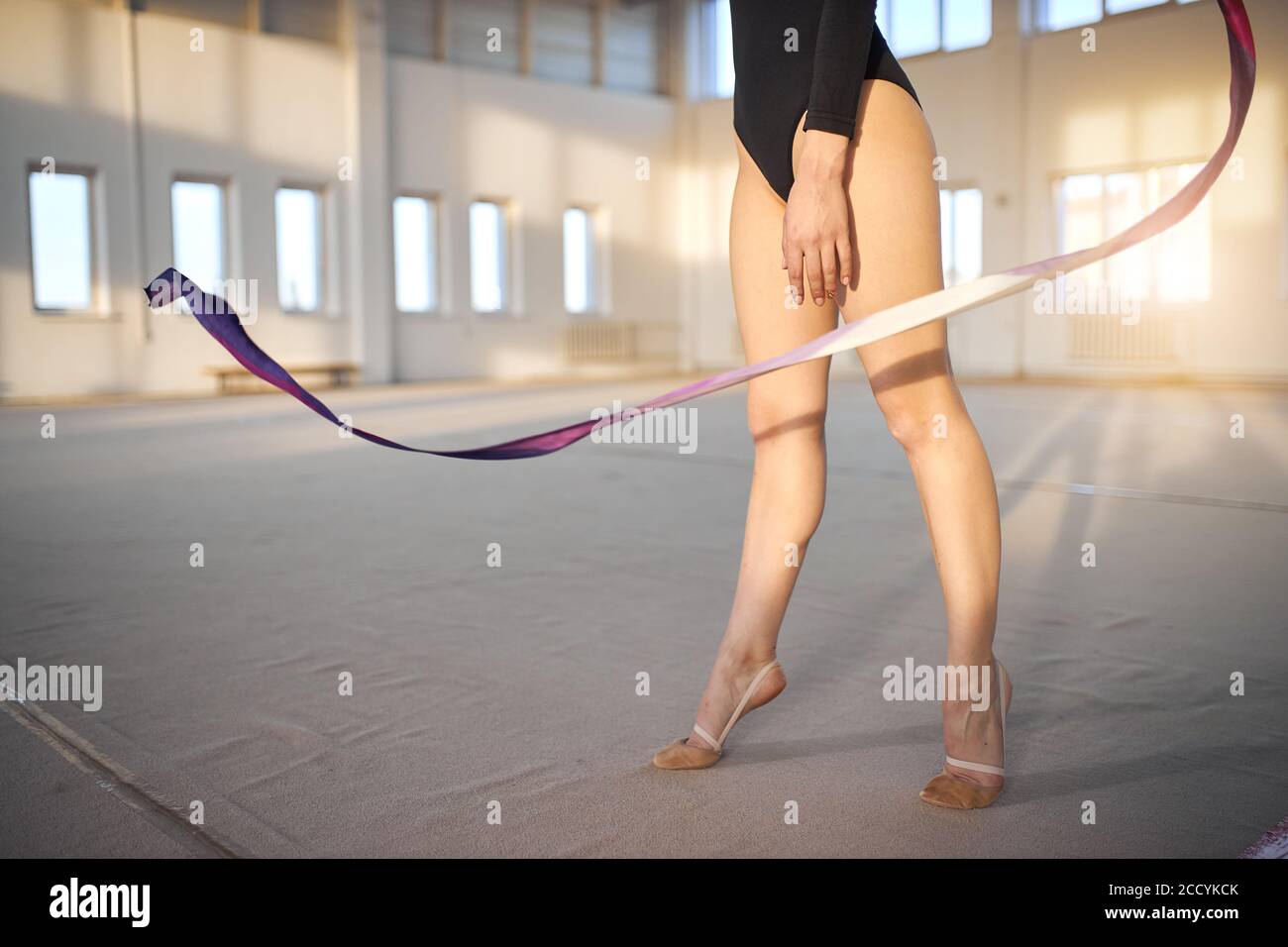 Close up of tall graceful legs of young talented art gymnast, standing
