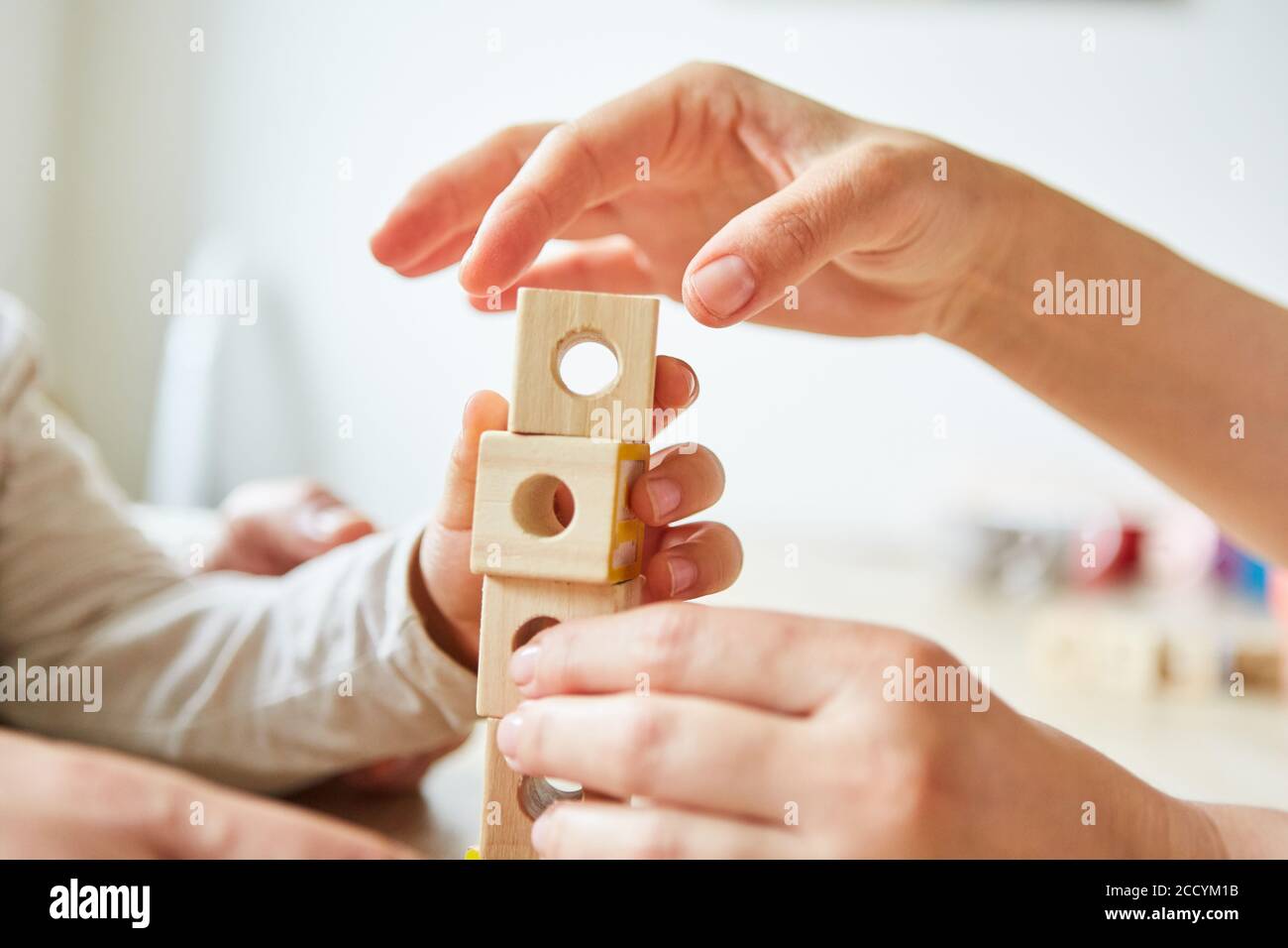 Seniors hands stacking wooden building blocks in occupational therapy