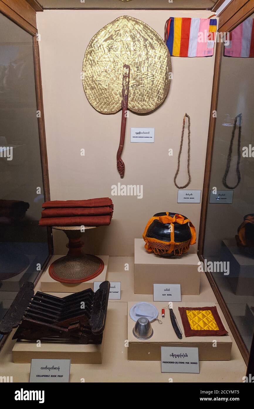 Attire for buddhist monks exposed in museum. Alms bowl, hand fan, lectern, tea cup and filter, razor to shave head, needle, thread. Myanmar, Asia Stock Photo