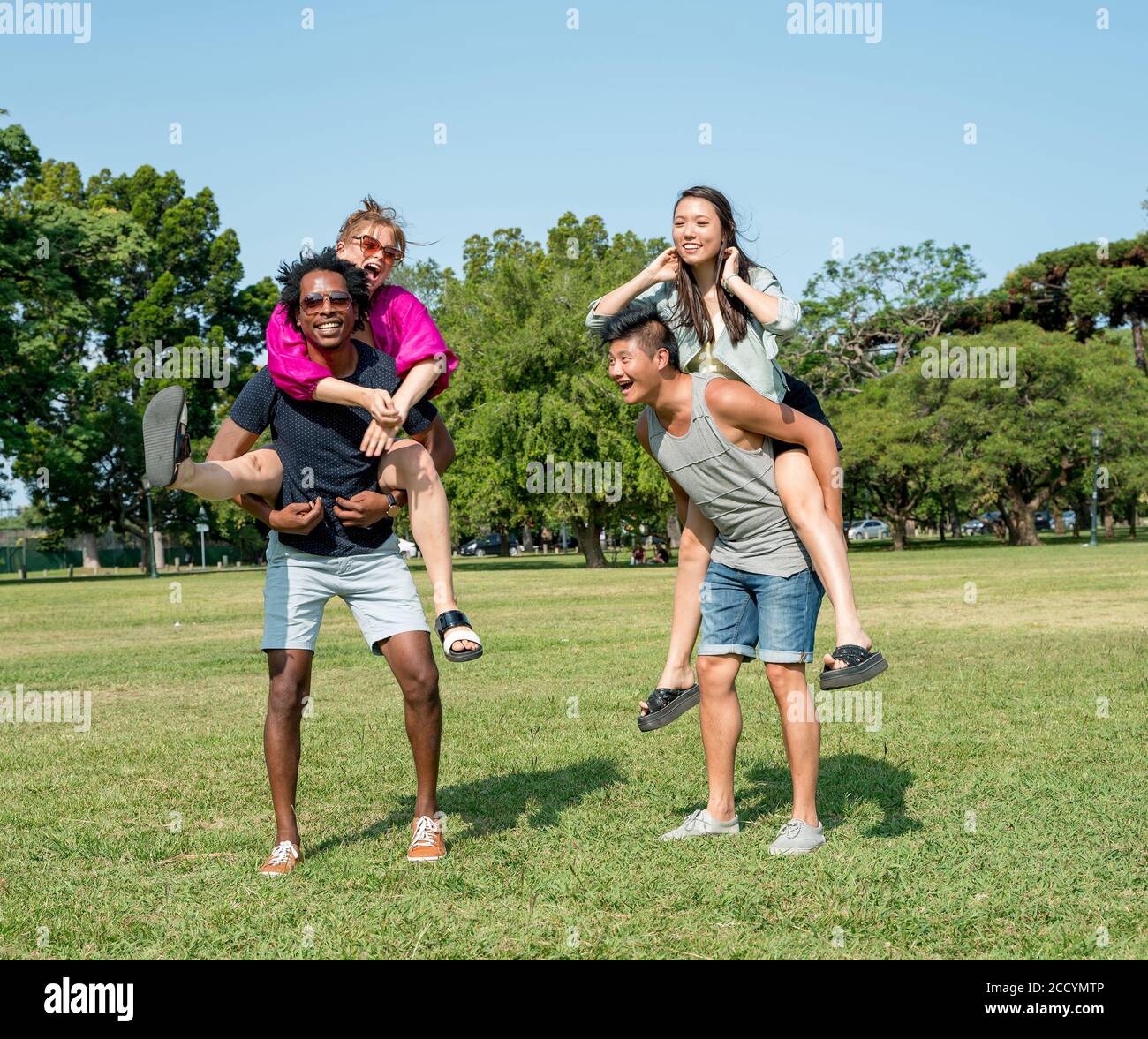Two young couples and friends having fun together in a park of a big ...