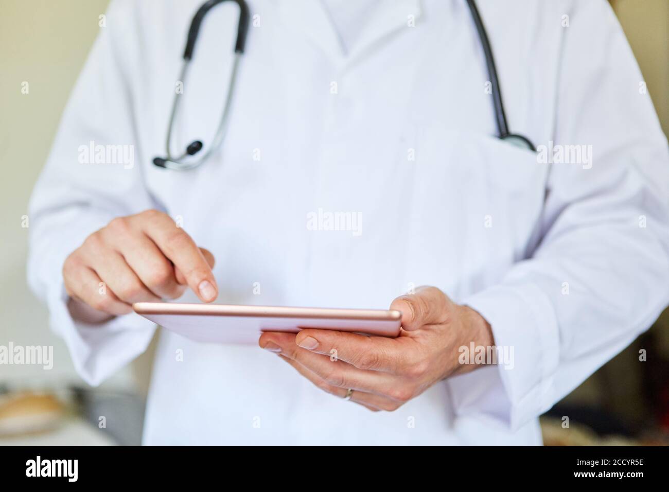 Doctor with tablet computer uses health app or researches on the internet Stock Photo