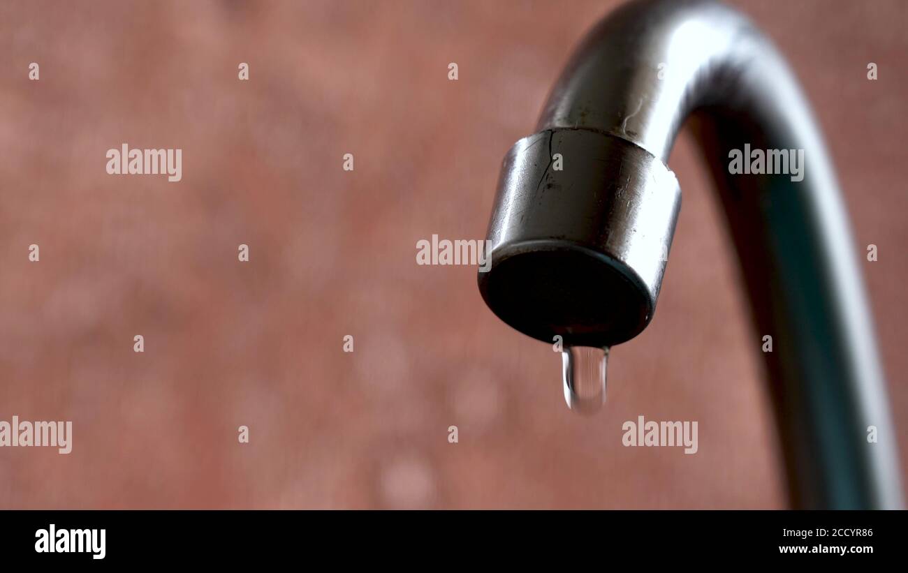 The old tap on the kitchen mixer is leaking. Tap water dripping. Daylight macro photography Stock Photo