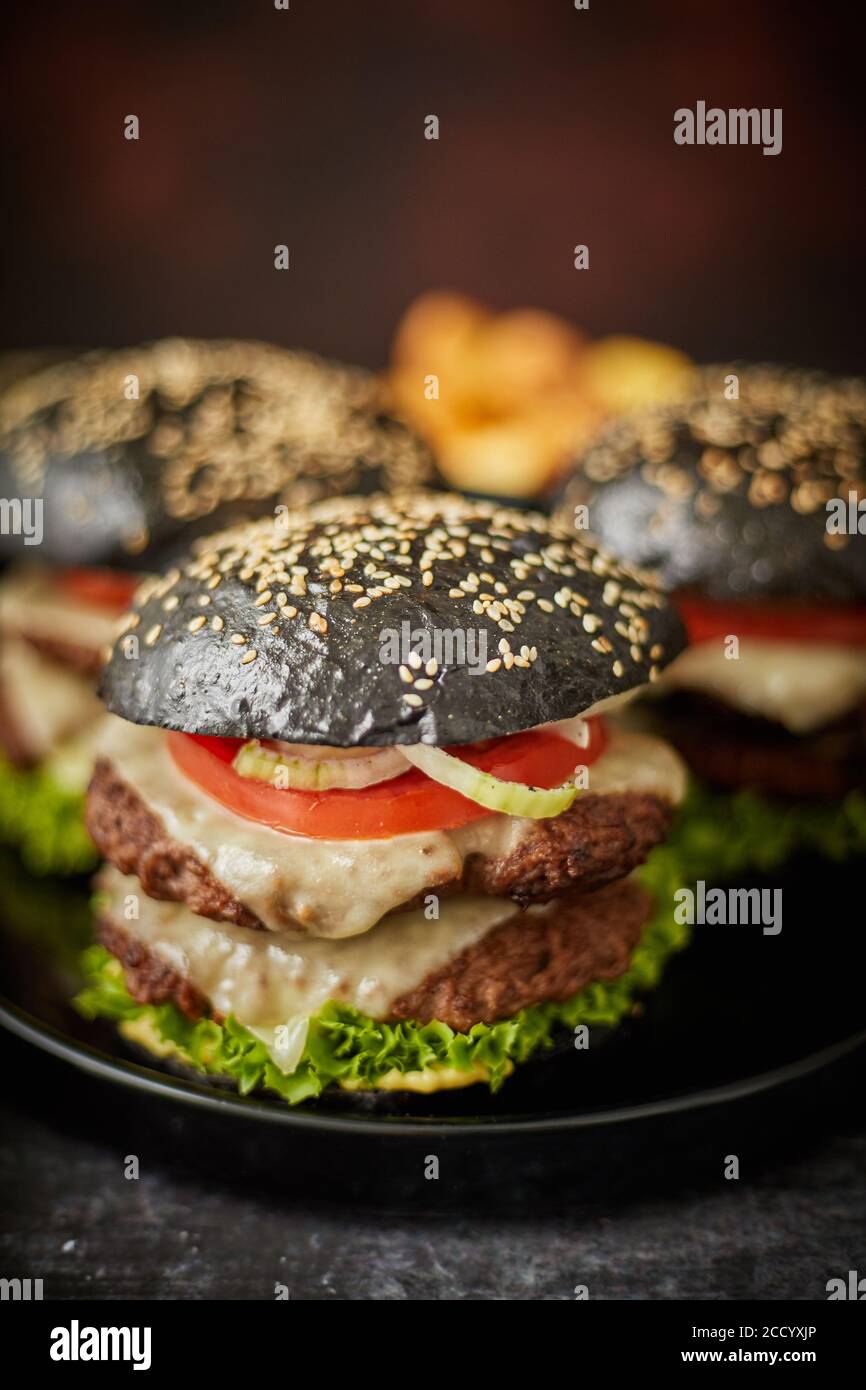 Black double cheeseburger with tomatoes and lettuce Stock Photo Alamy