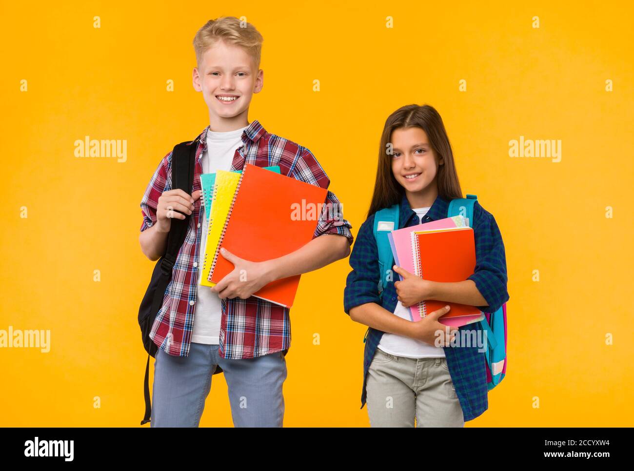 Smiling teens posing with textbooks at studio Stock Photo