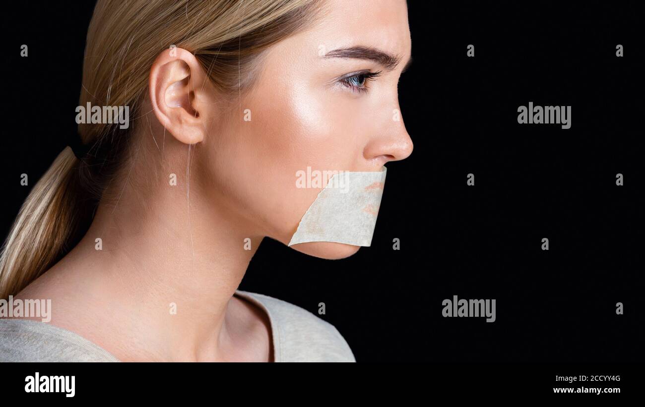 Domestic violence and sexism. Desperate girl with sealed mouth with tape Stock Photo