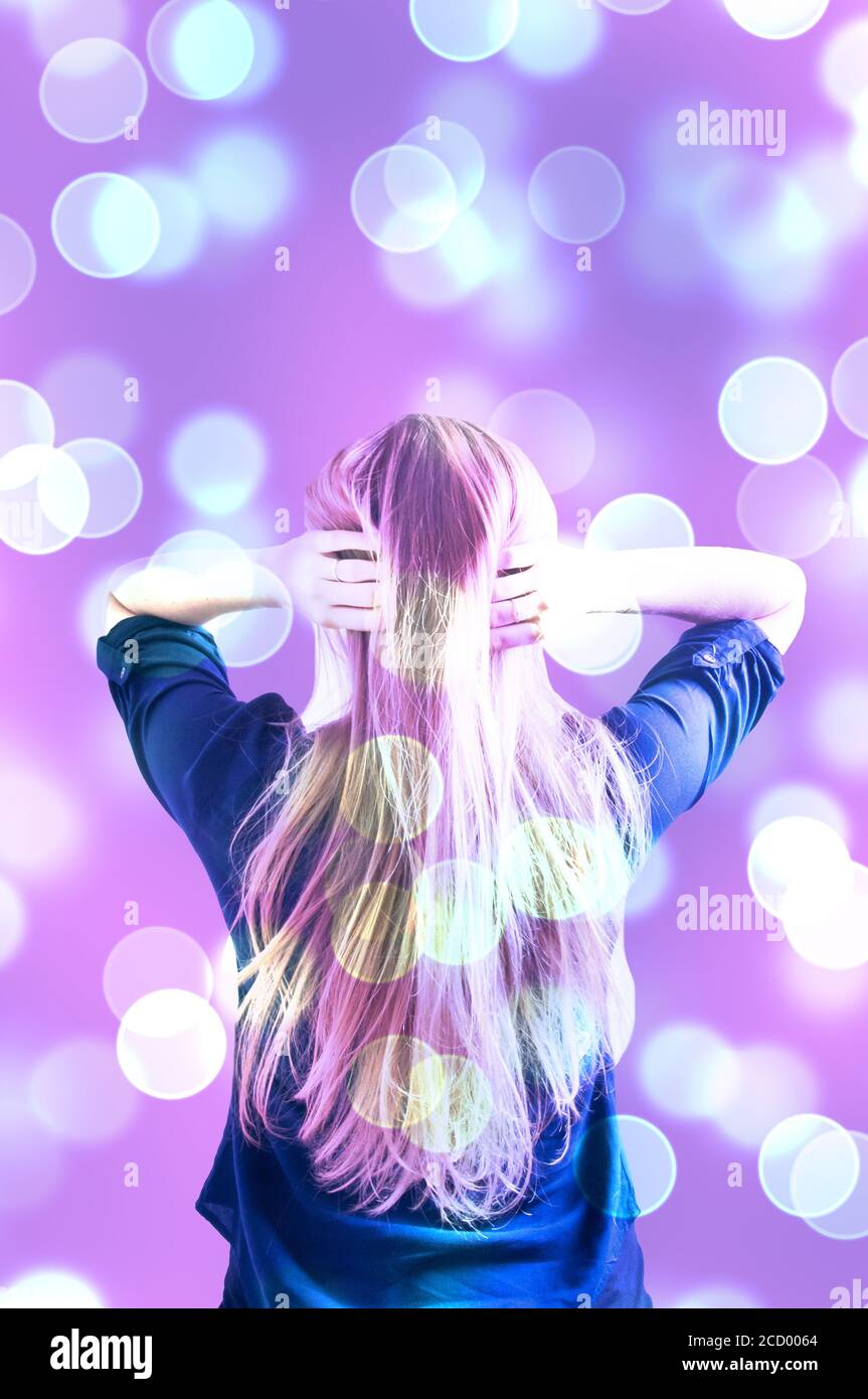blond young woman with long hair from the back, bokeh effect Stock Photo