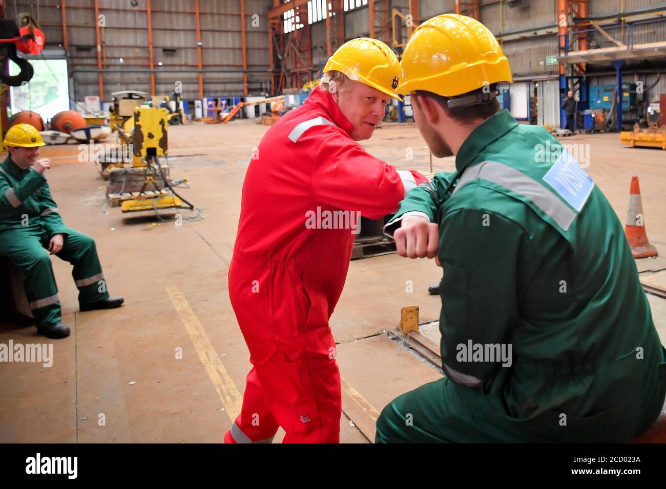 Prime Minister Boris Johnson greets students from Petroc college in Braunton, with an elbow-bump during his visit to Appledore Shipyard in Devon which was bought by InfraStrata, the firm which also owns Belfast's Harland & Wolff (H&W), in a £7 million deal. Stock Photo