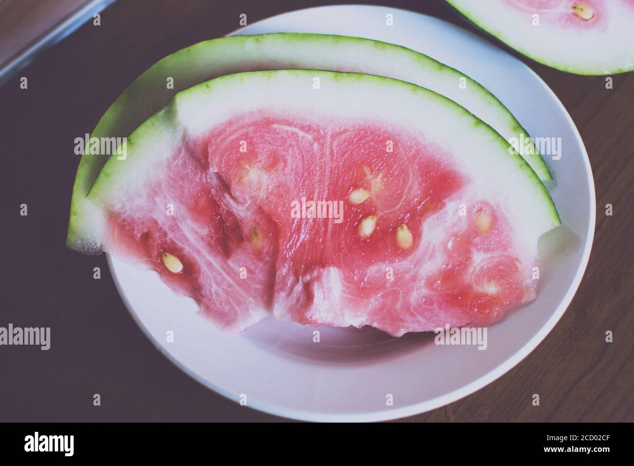 slices of unripe watermelon with white seeds on the table Stock Photo ...