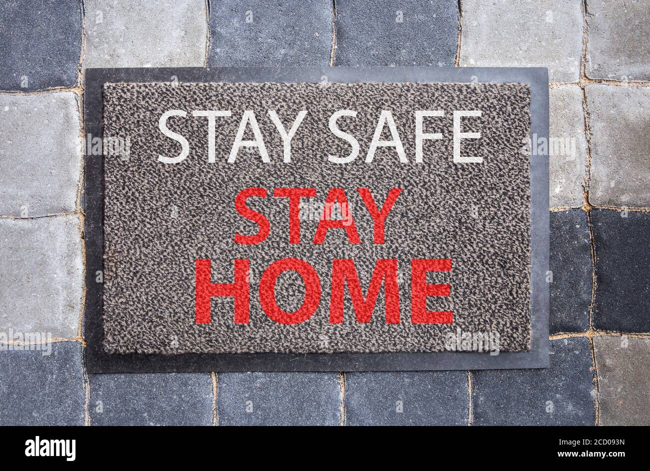Disease avoid spread concept. Home doormat with text: Stay safe, stay home. Home decor with message. Stock Photo