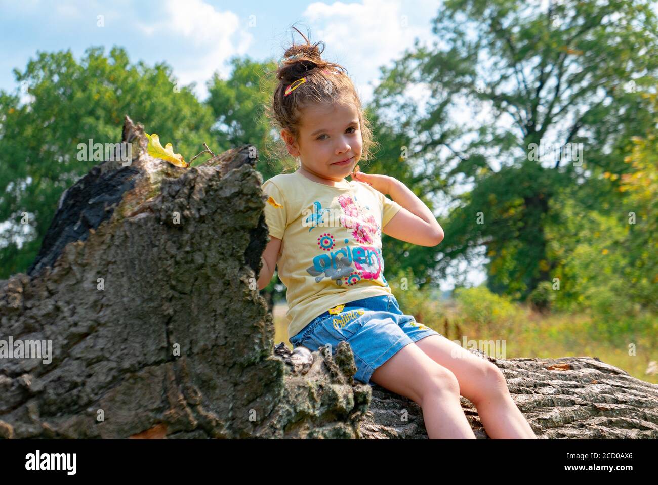 Little girl having fun on the big tree in the oak forest Stock Photo ...