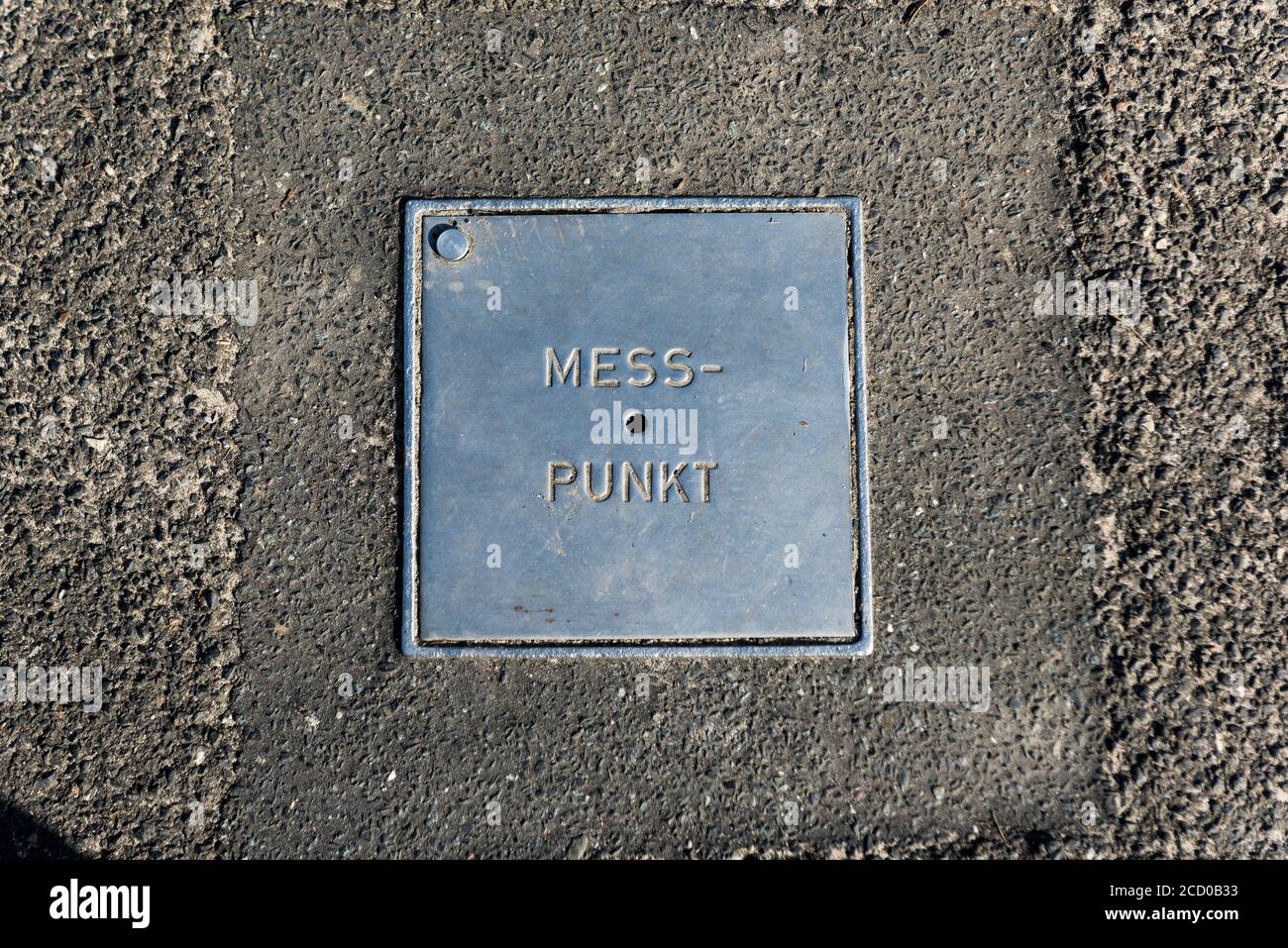 A metal plate with the inscription 'Messpunkt' Point of Measurement is embedded in the floor Stock Photo