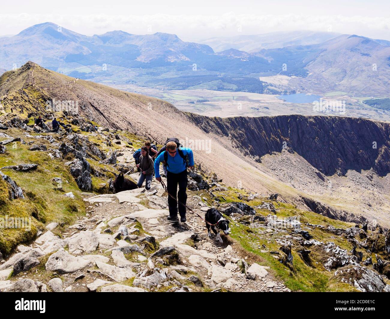 Hikers with a dog on Rhyd Ddu path at Bwlch Main hiking up Mt Snowdon with view to Llechog in Snowdonia National Park, Gwynedd, Wales, UK, Britain Stock Photo