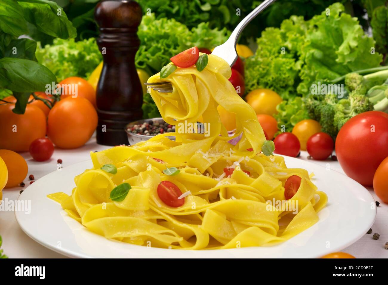 Plate of italian pasta, fettuccine on fork with tomatoes and basil Stock Photo
