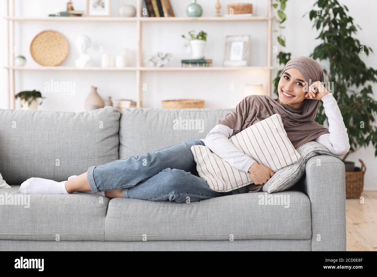 Relaxed Arabic Woman Lying On Couch At Home Cuddling Pillow Enjoying Weekend Stock Photo Alamy