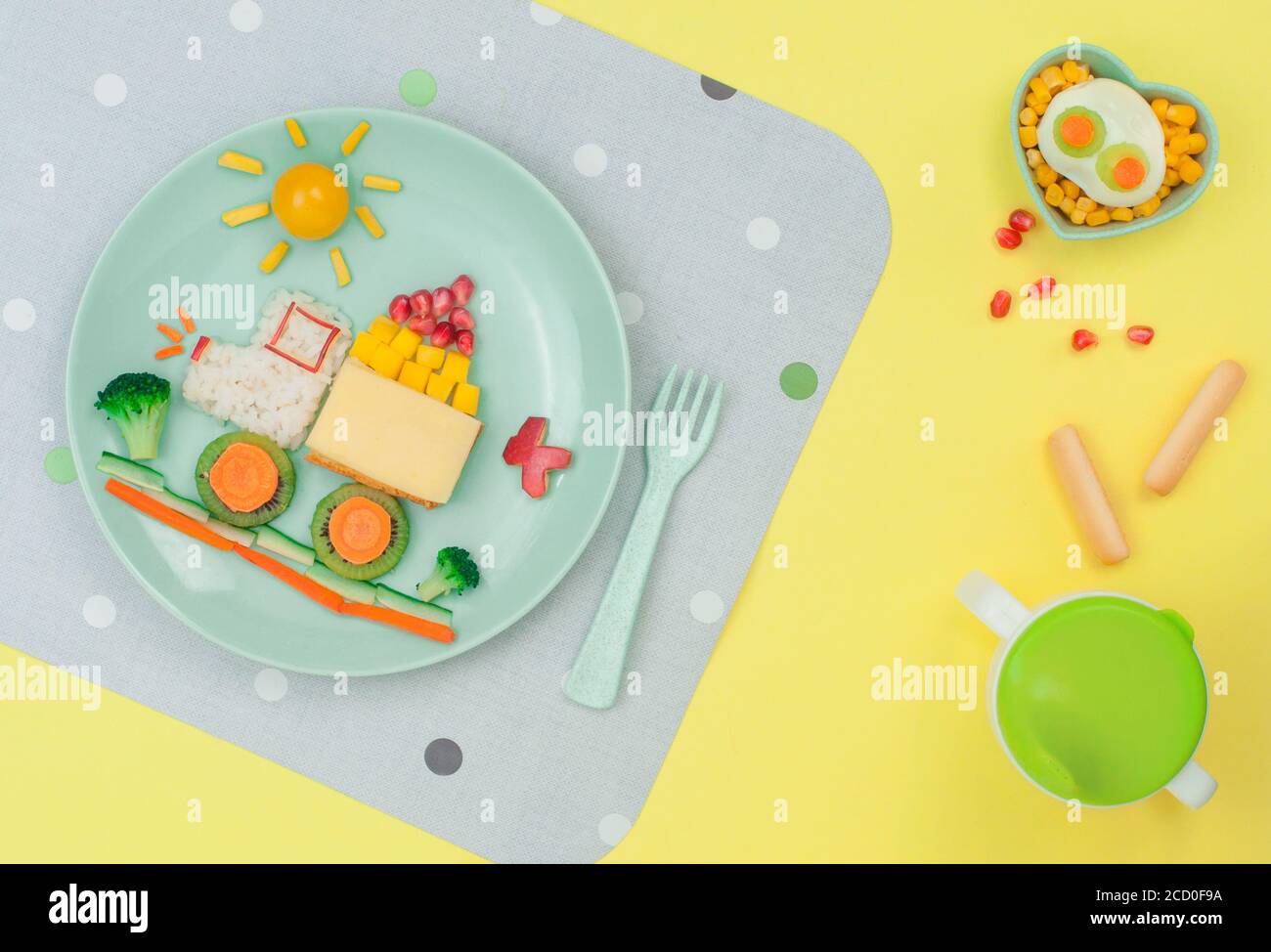 Kids food art concept: car from rice, sandwich and fresh fruits and vegetables on the yellow background; top view, flat lay Stock Photo
