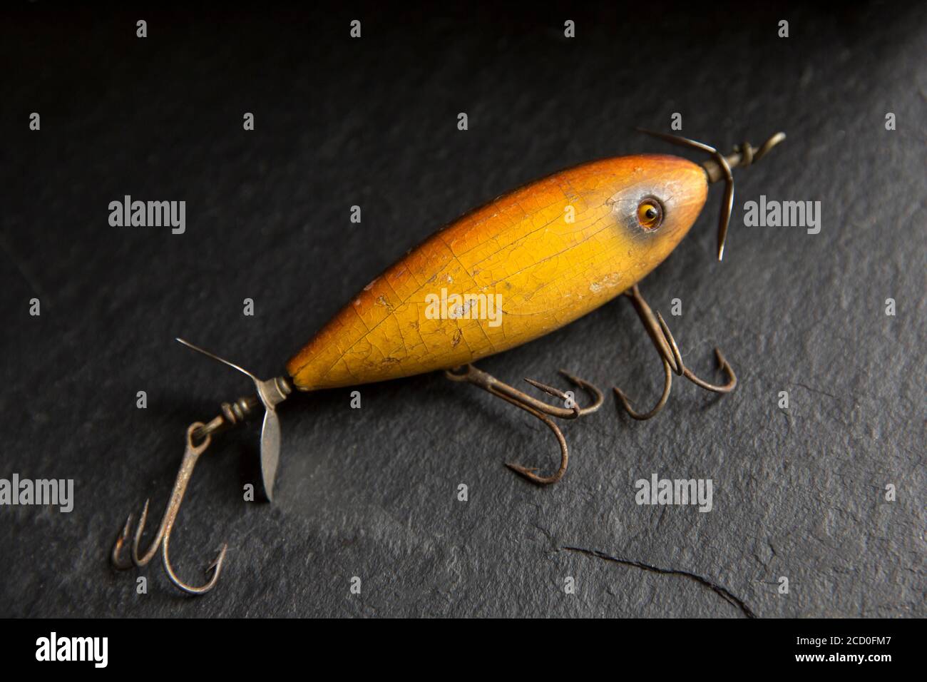 An example of an old South Bend fishing lure, or plug, designed to catch predatory fish displayed on a dark slate background. From a collection of vin Stock Photo