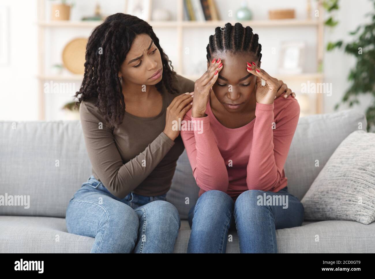 Black girl comforting her sad friend, home interior Stock Photo - Alamy