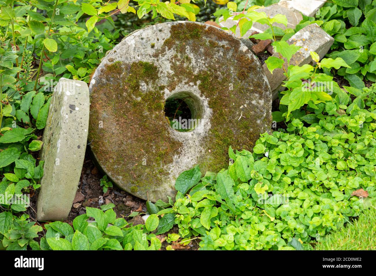 Millstones in a garden, UK Stock Photo Alamy