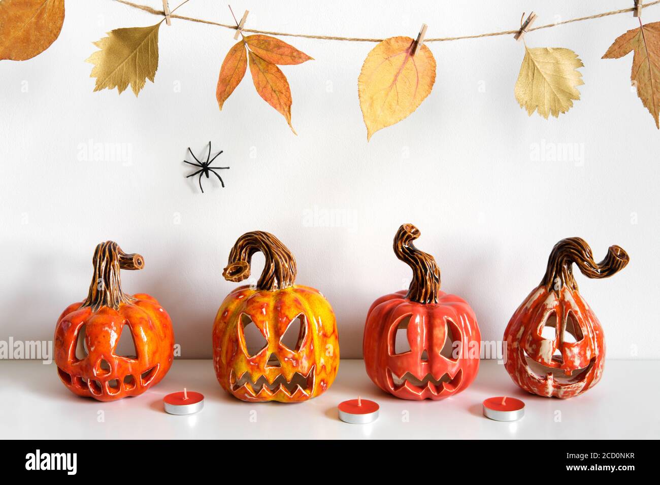 Halloween composition with ceramic pumpkins jack lantern and candles on  table wall background. Home decoration Stock Photo - Alamy