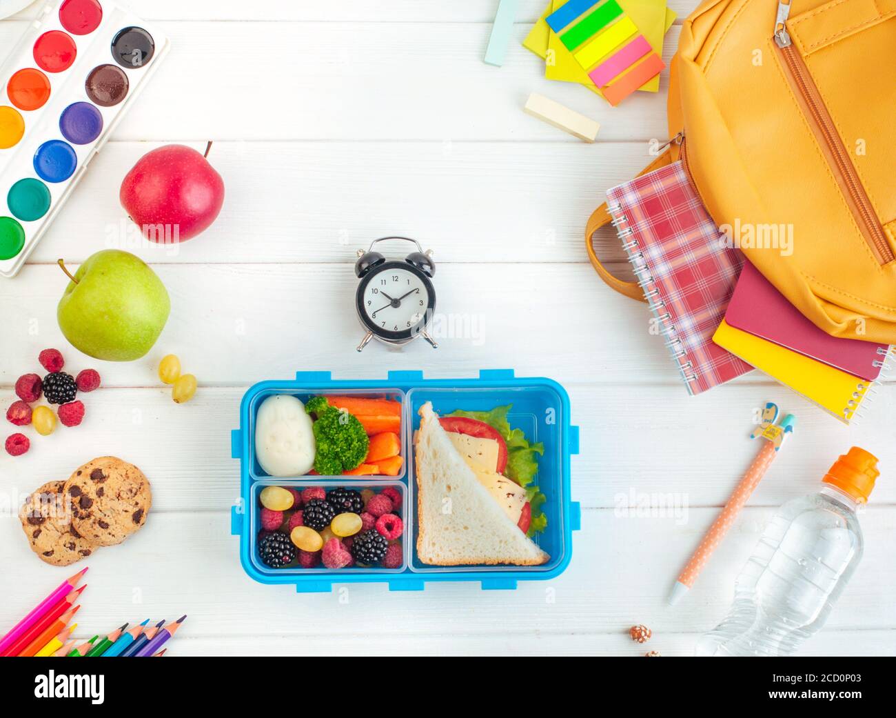 https://c8.alamy.com/comp/2CD0P03/open-lunch-box-with-sandwich-vegetables-egg-fresh-berries-on-the-white-wooden-background-near-clock-and-school-accessories-top-view-flat-lay-2CD0P03.jpg