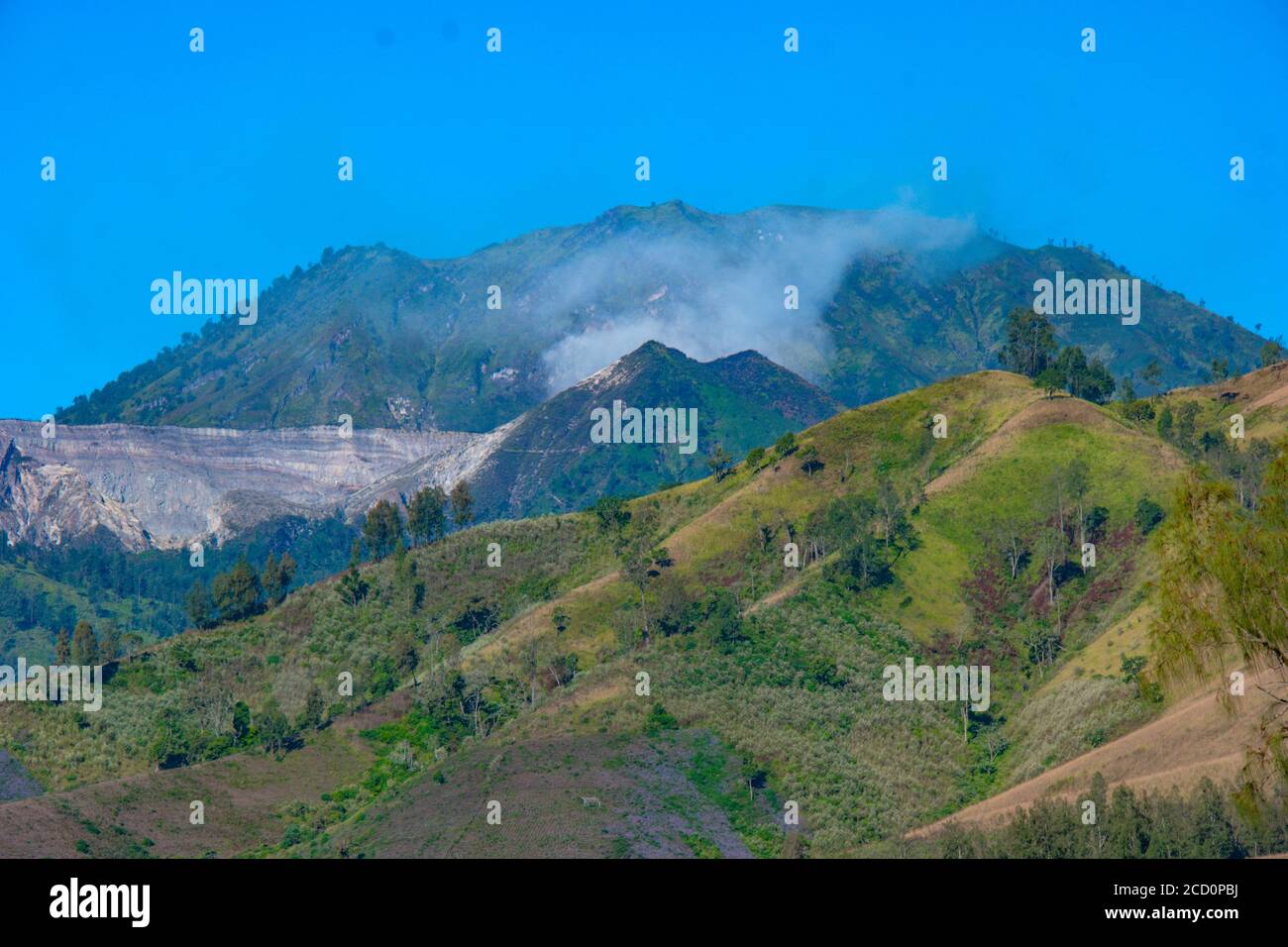 Sloping Ridges View of mountain ridges and sloping hills with trees under a clear blue ...