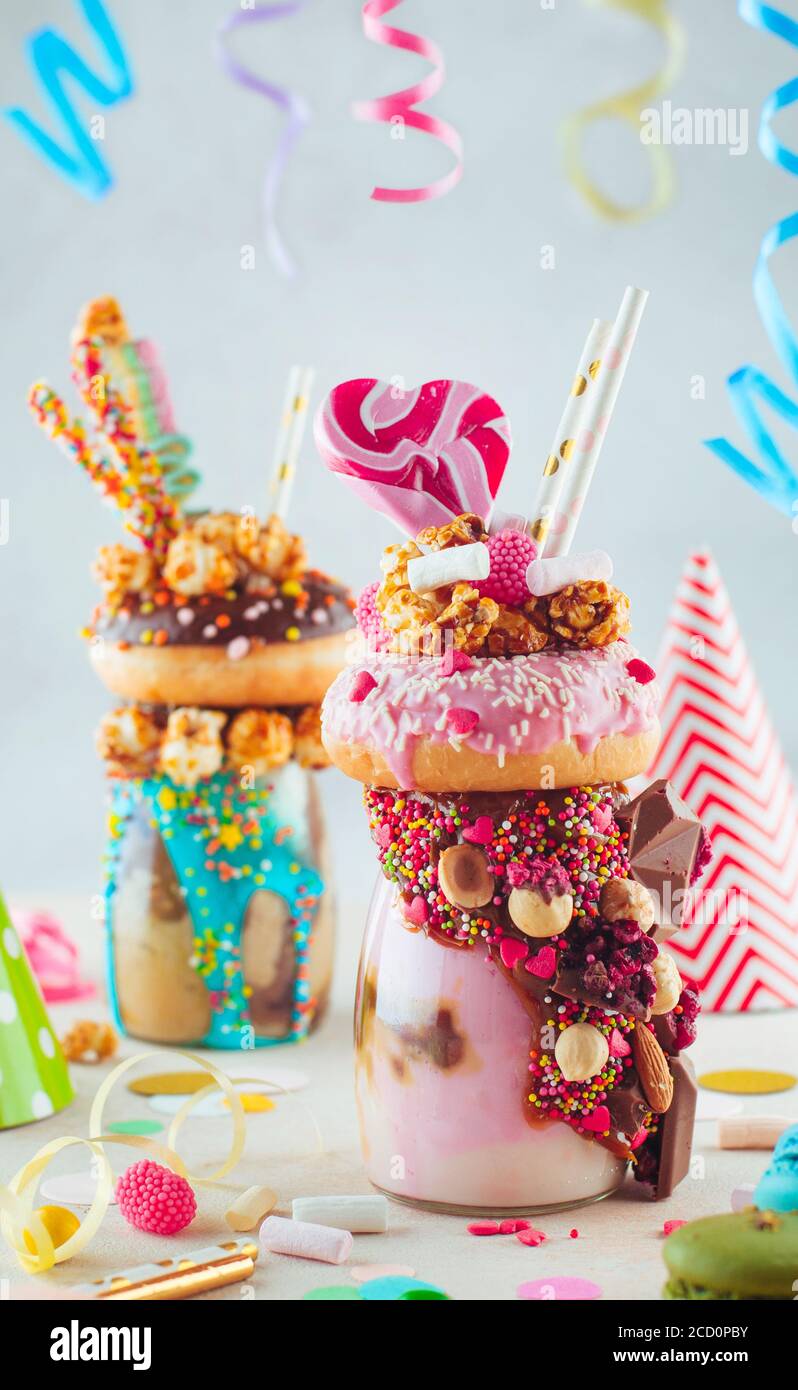https://c8.alamy.com/comp/2CD0PBY/kids-party-concept-raspberry-freak-shake-topping-with-donut-and-caramel-popcorn-and-decorated-with-caramel-and-milk-chocolate-on-party-table-selecti-2CD0PBY.jpg