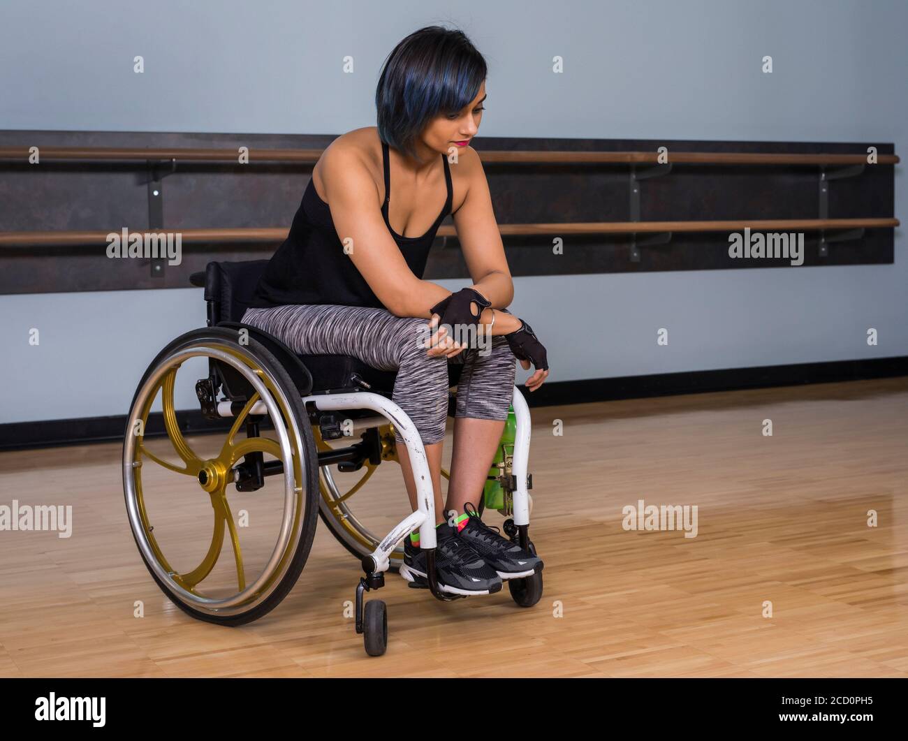 A paraplegic woman looking discouraged while taking a break from working out in a recreational facility: Edmonton, Alberta, Canada Stock Photo