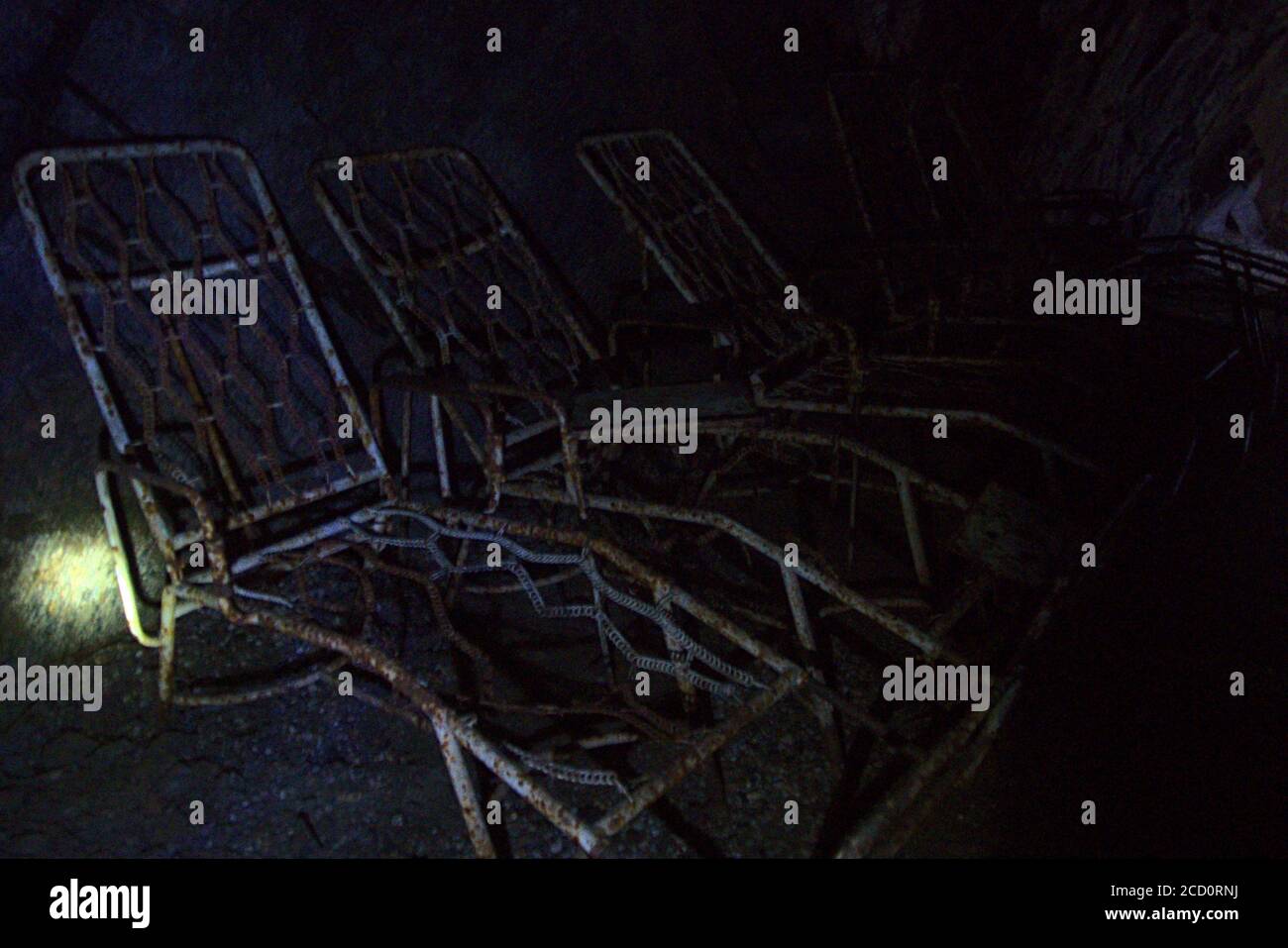 Extremely rusted sunbeds in an abandoned uranium mine Stock Photo