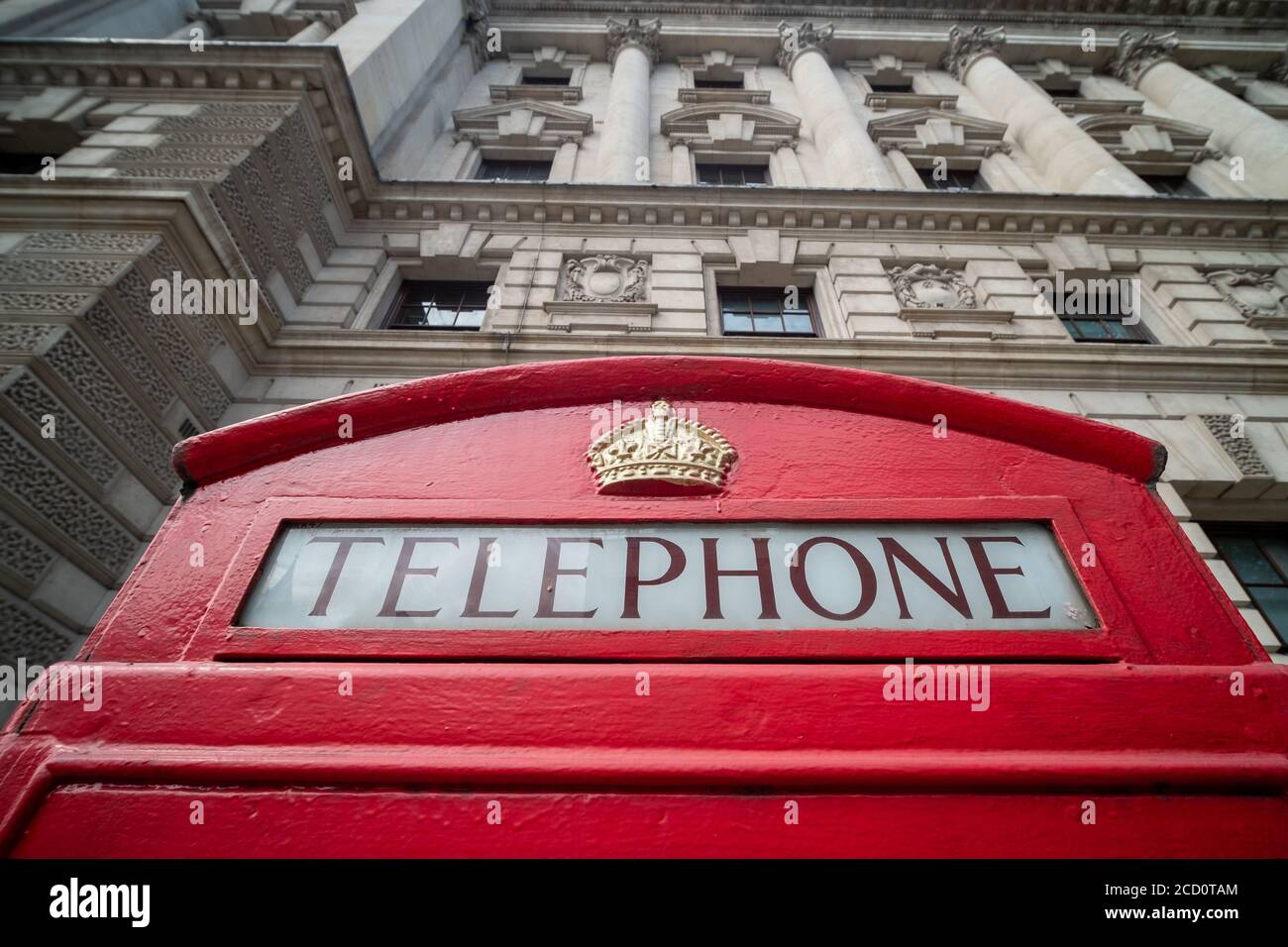 A red London telephone booth outside government building on Whitehall, London Stock Photo