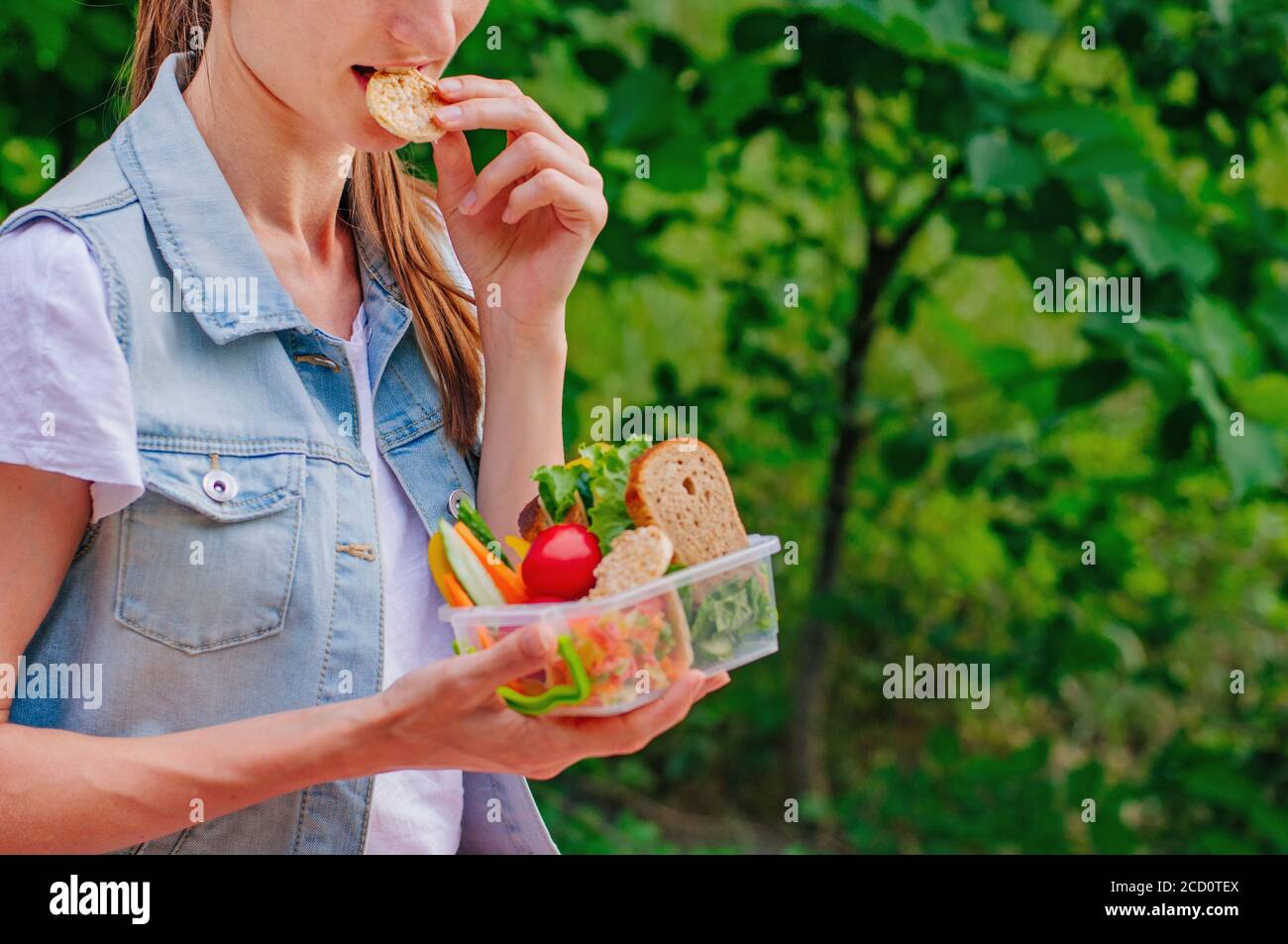 Healthy food concept: Young hipster girl eating from lunch box filled ...