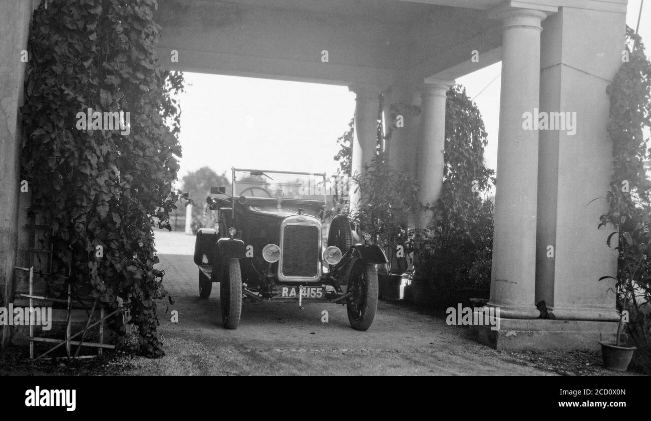 A vintage 1920s black and white photograph showing a British Clyno Motor car parked outside a large house. Car has registration number RA 4155. Stock Photo