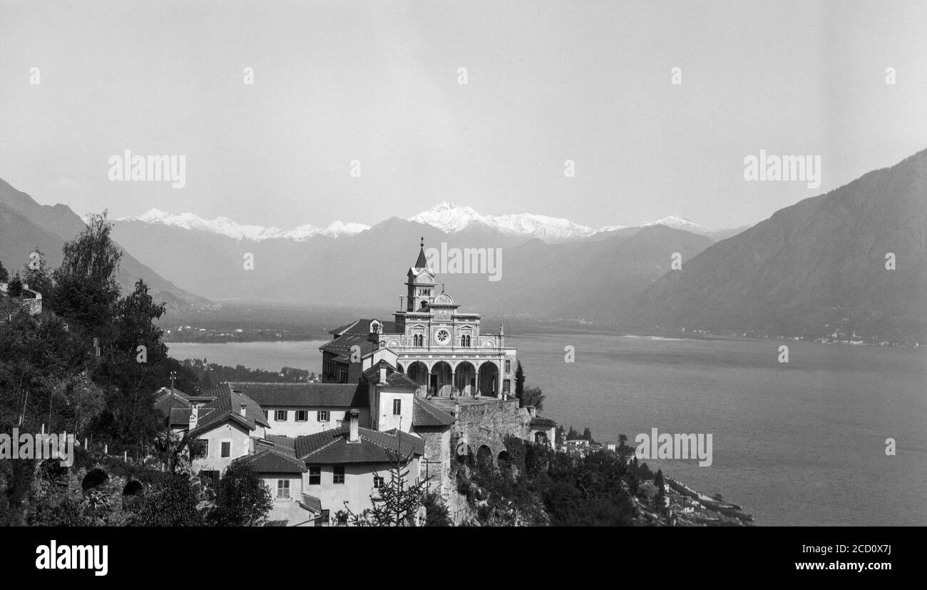 A vintage 1920s black and white photograph showing the Madonna del Sasso sanctuary and pilgrim church above the city of Locarno in Switzerland. Stock Photo