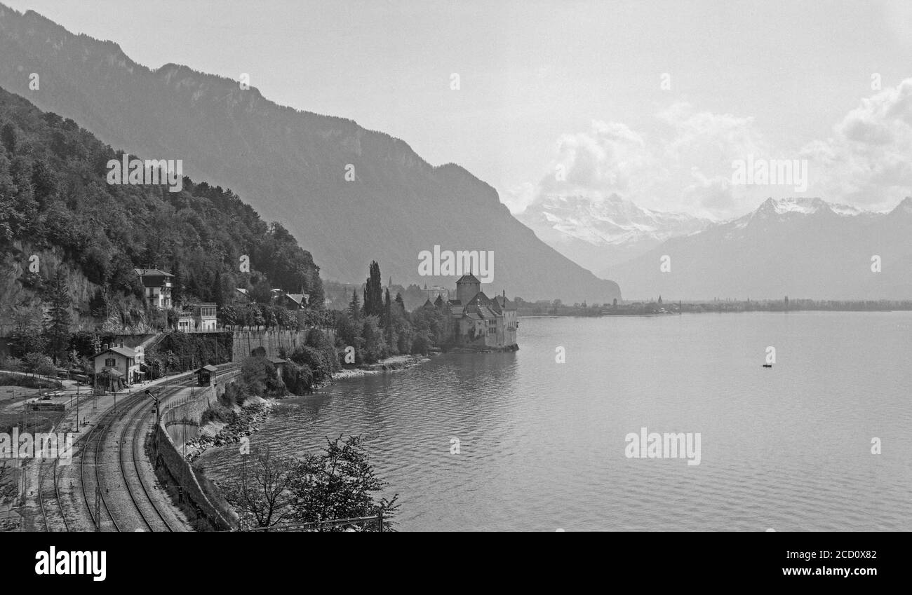 A vintage 1920s black and white photograph showing Lake Geneva inn Switzerland with Chillon Castel or Chateau de Chillon. Stock Photo
