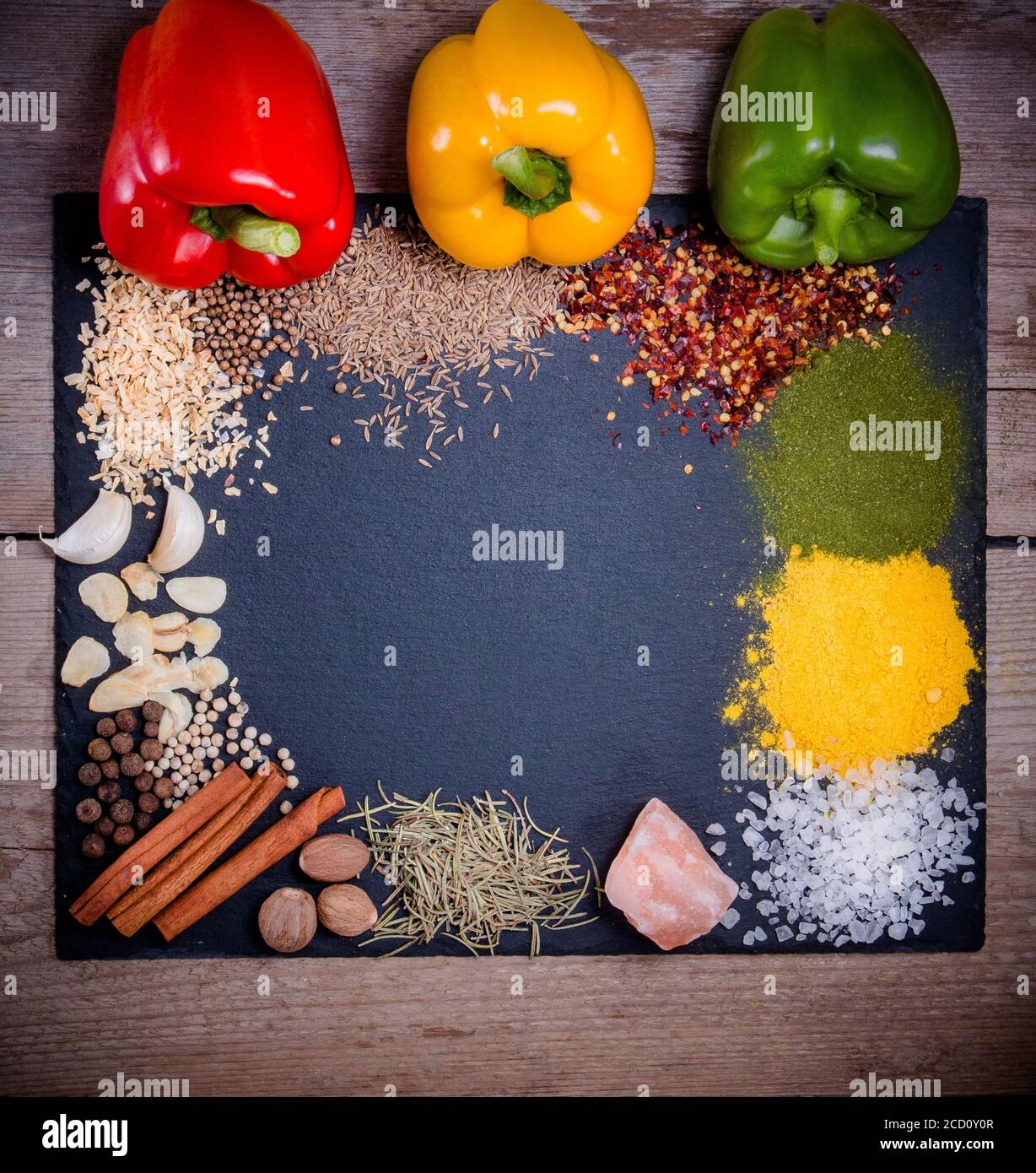 Spices, herbs and fresh pepper on slate tray on an old rustic table. Red, yellow and green fresh peppers. Top view. Rustic style. Fresh ingredients an Stock Photo