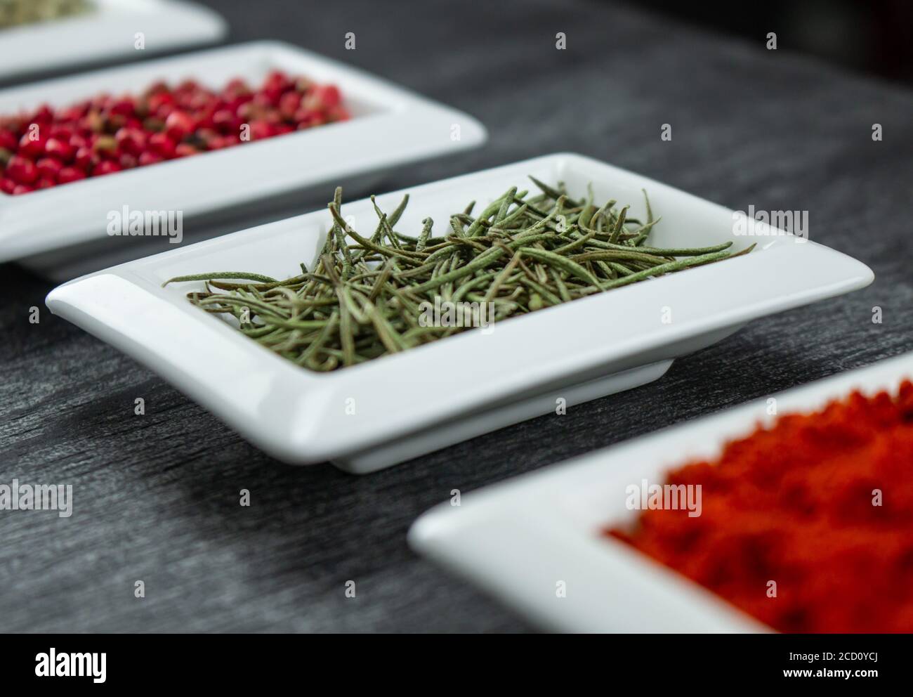 Rosemary herb. Colorful spices in white bowls Seasonings for cooking
