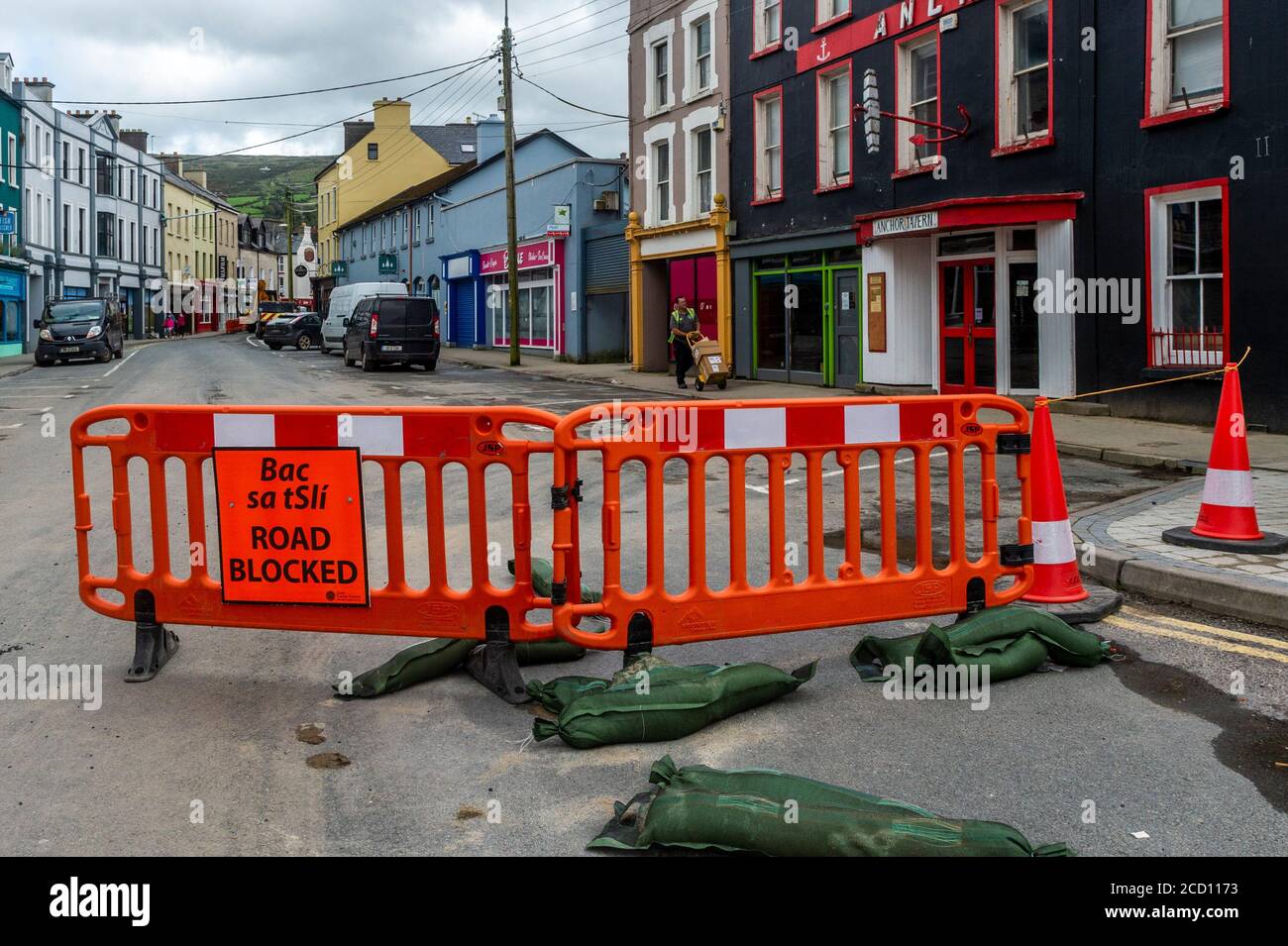 Bantry, West Cork, Ireland. 25th Aug, 2020. Bantry town was the victim of major floods last night with at least 50 homes and businesses suffering significant water and mud damage. The floods happened during a 4 hour deluge of rain. The force of the water ripped up part of the road in New Street. Cork County Council is pictured making emergency repairs to the road. Credit: AG News/Alamy Live News Stock Photo