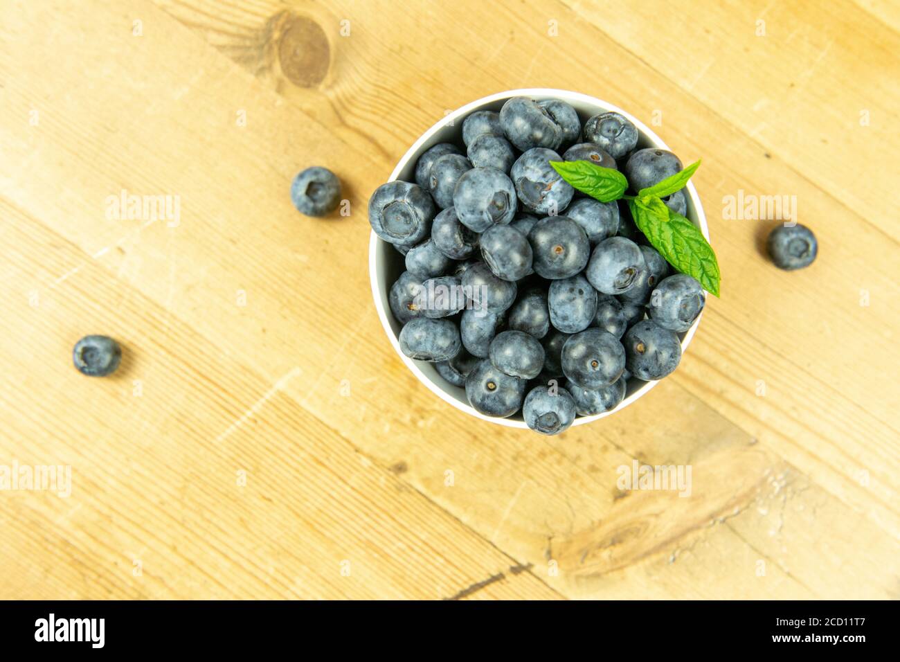 Fresh blueberries in a yellow contorting bowl Stock Photo