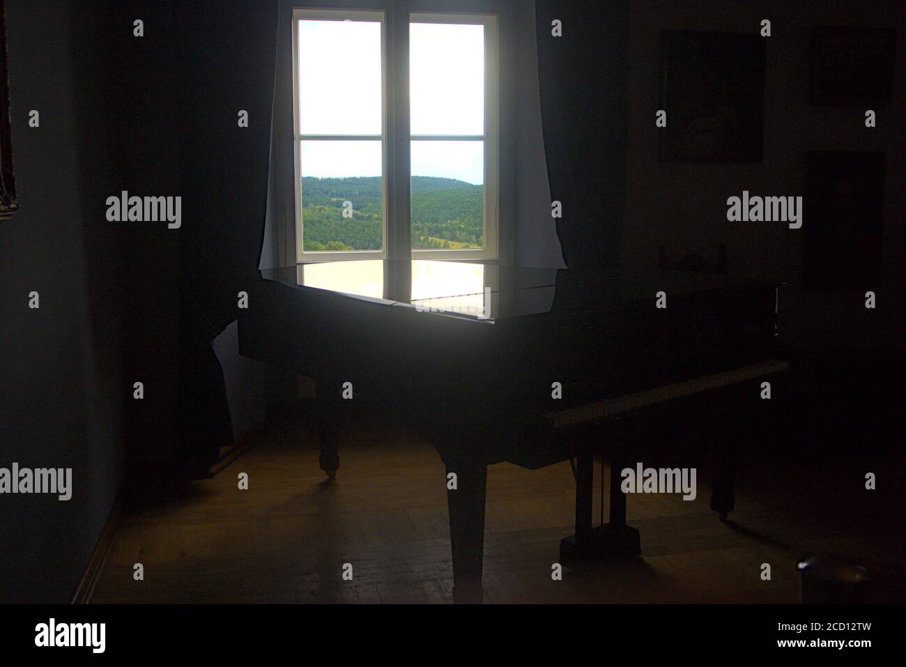 A luxurious black piano by an open window Stock Photo