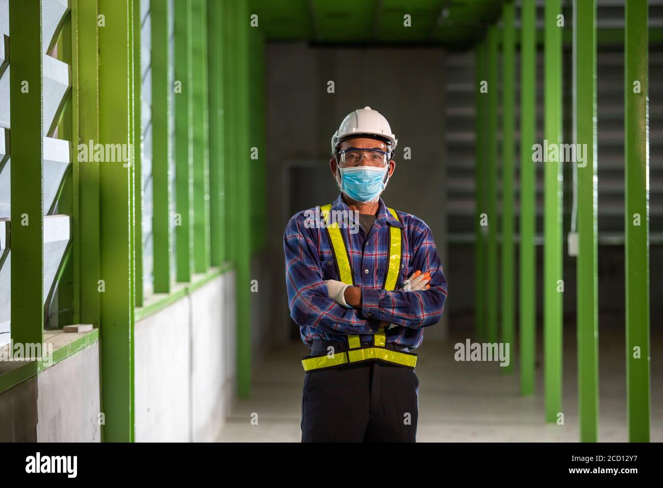 Asian industrial senior  man works with a face mask. Safety for work concept in the factory Stock Photo