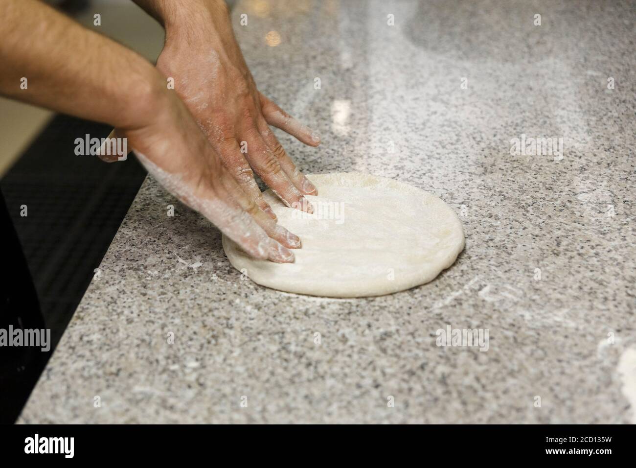 Making dough by male hands on table background. Pizza maker prepares a ...