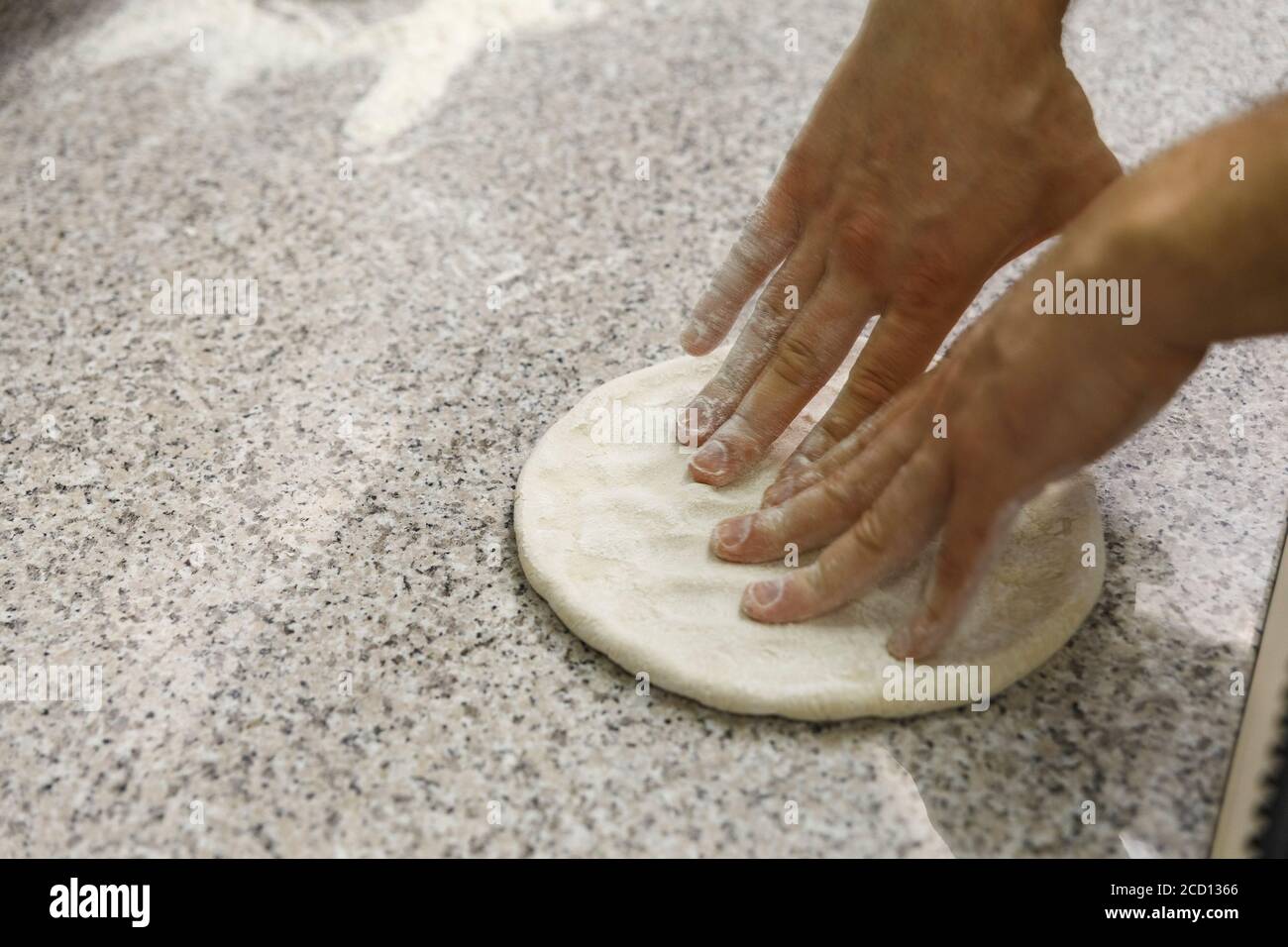 Making dough by male hands on table background. Pizza maker prepares a ...