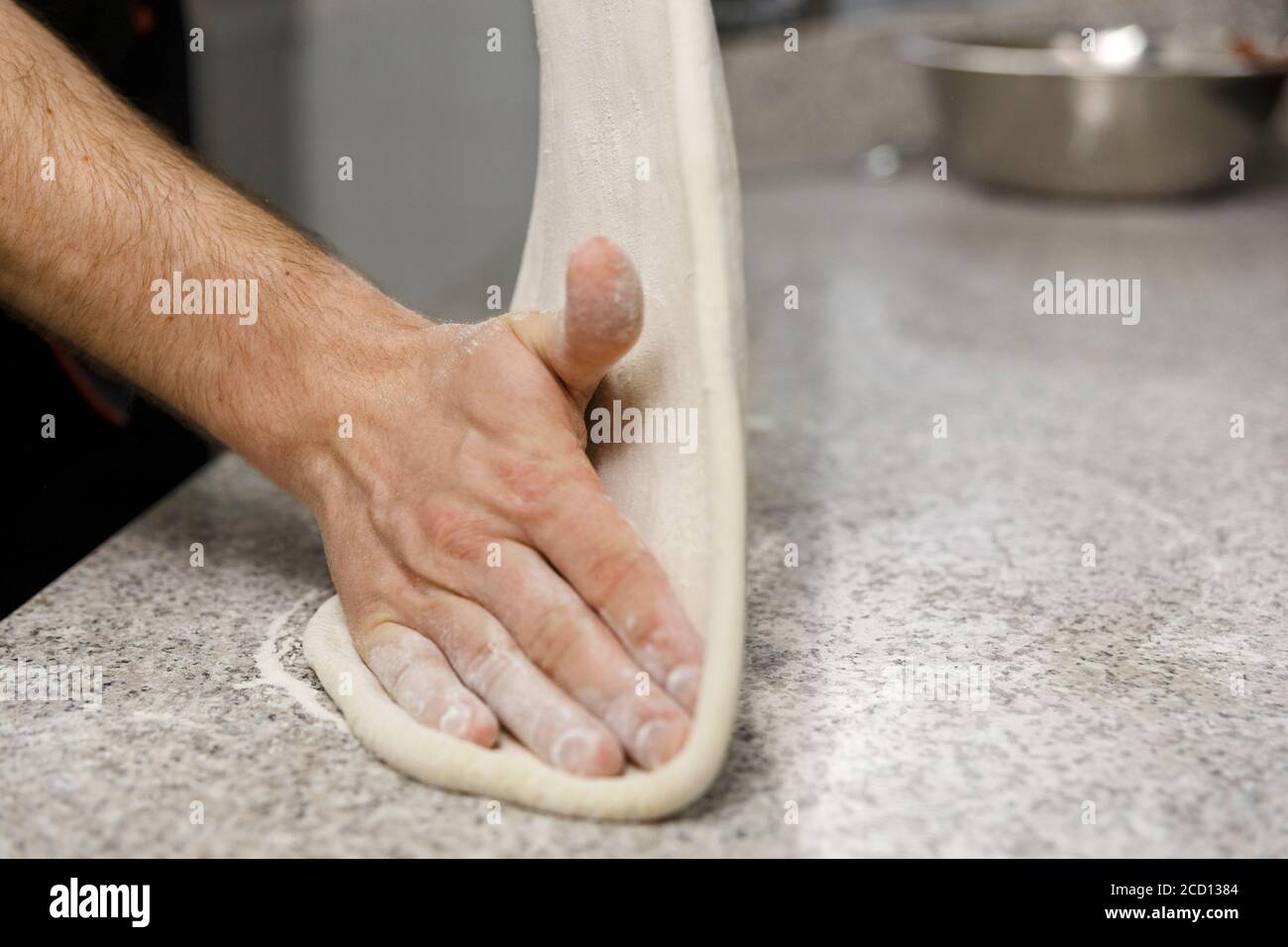 Making dough by male hands on table background. Pizza maker prepares a ...