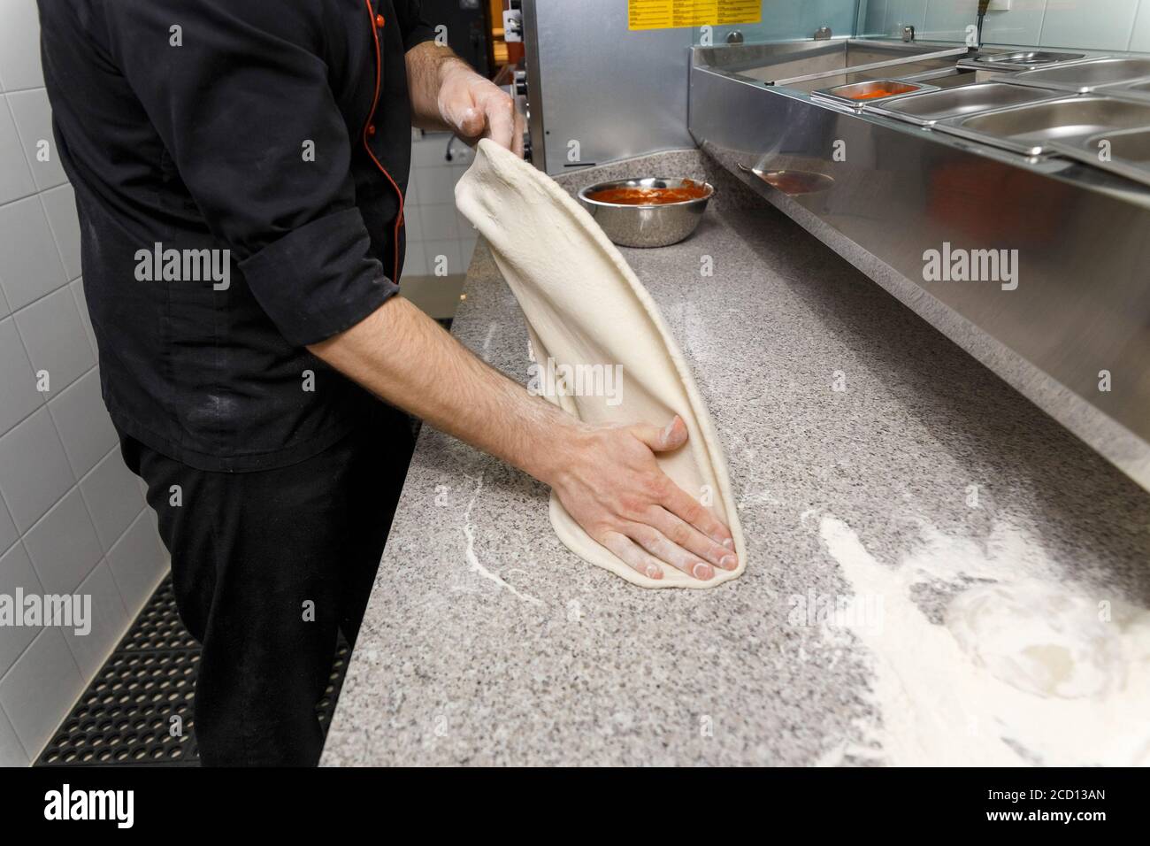 Making dough by male hands on table background. Pizza maker prepares a ...