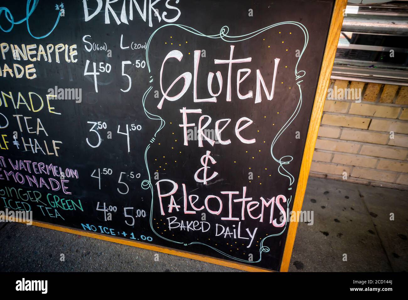 A sign outside a bakery in New York on Thursday, August 20, 2020 promotes their gluten free and paleo menu items. The protein gluten is found in wheat and is a flavoring and thickening food additive. People with celiac disease, dermatitis herpetiformis  and wheat allergies eat a gluten-free diet to prevent their disease or allergy. (© Richard B. Levine) Stock Photo