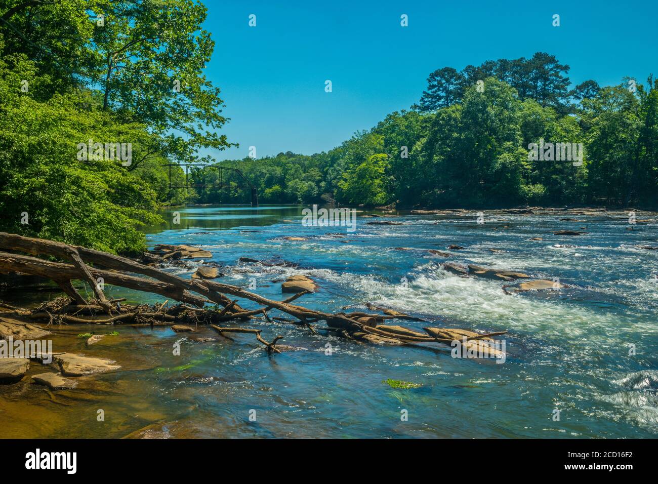 A view down the chattahoochee river with remains of an old iron bridge in the background on a