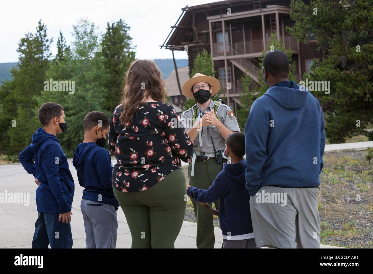 A National Park Ranger advises visitors outside the closed The Old Faithful Visitor Education Center in Yellowstone National Park, Wyoming on Monday, Stock Photo